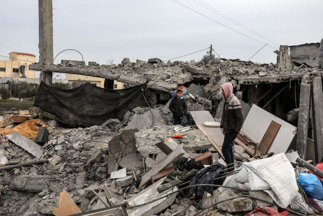 Un hombre y unos niños palestinos observan la destrucción que dejan los ataques aéreos de Israel sobre Rafah, en la zona sur de la Franja de Gaza.
